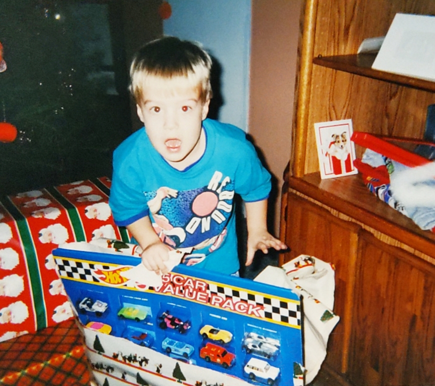 dan as a child opening a christmas present of toy cars