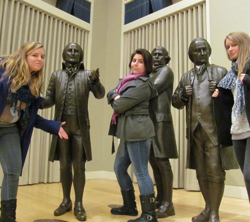 rachel, renata, and nora standing in front of 3 bronze statues of the founding fathers
