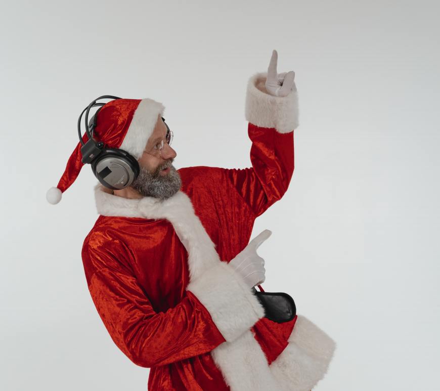 old man dressed as santa dancing with headphones on